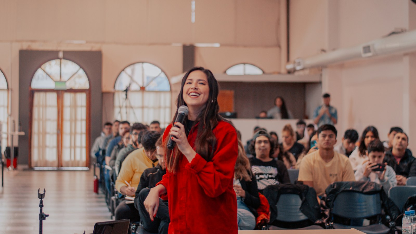 Woman standing in front of a crowd — konuşmacı ajansına başvuru