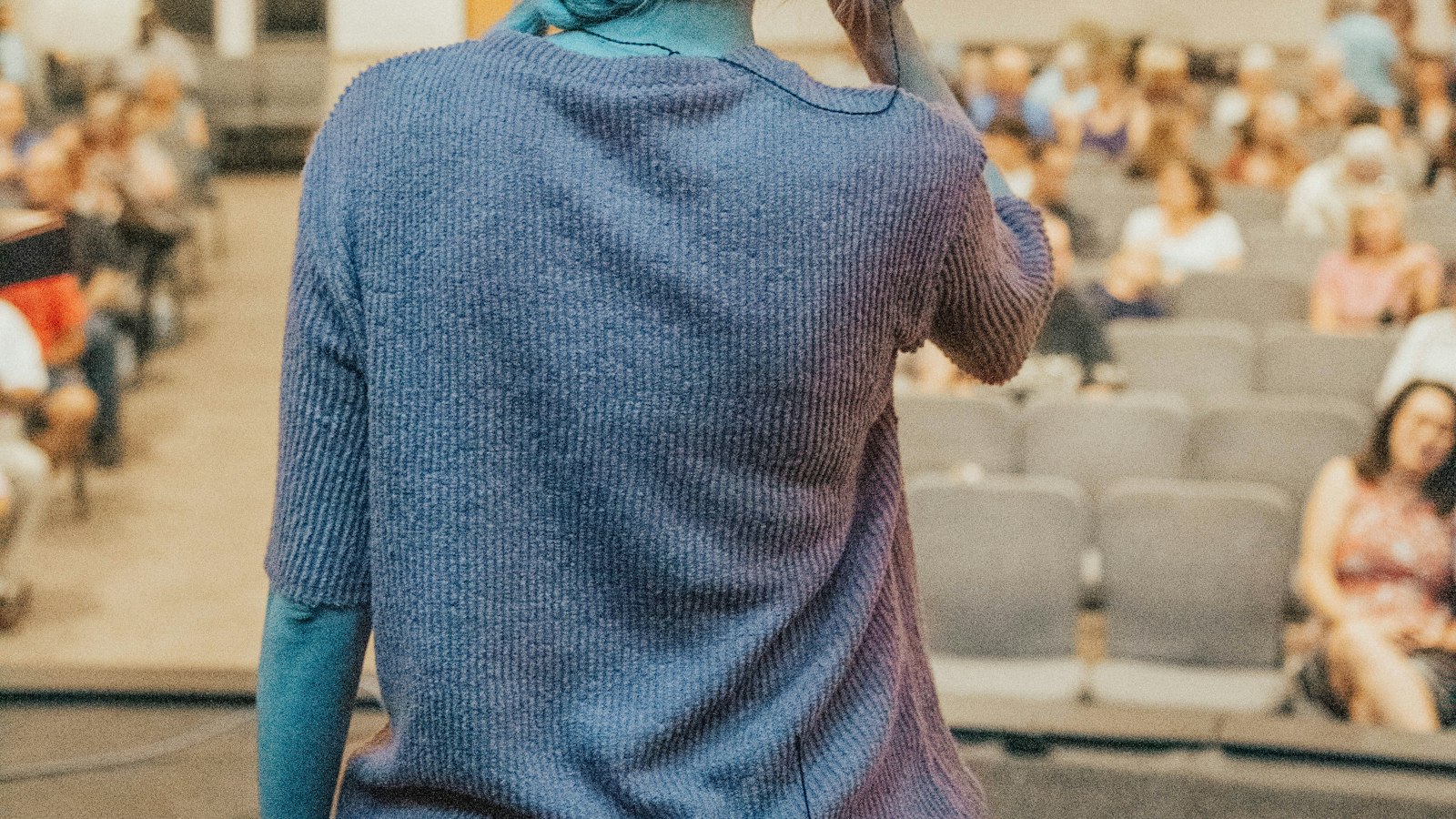 Woman standing in front of audience — konuşmacı tek sayfa profil